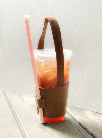 Same holder with a large Dunkin tea and a strap on the holder with a straw in it 