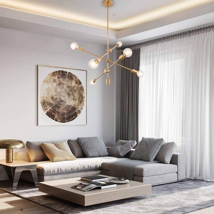 Brass sputnik chandelier shown in a modern living room.