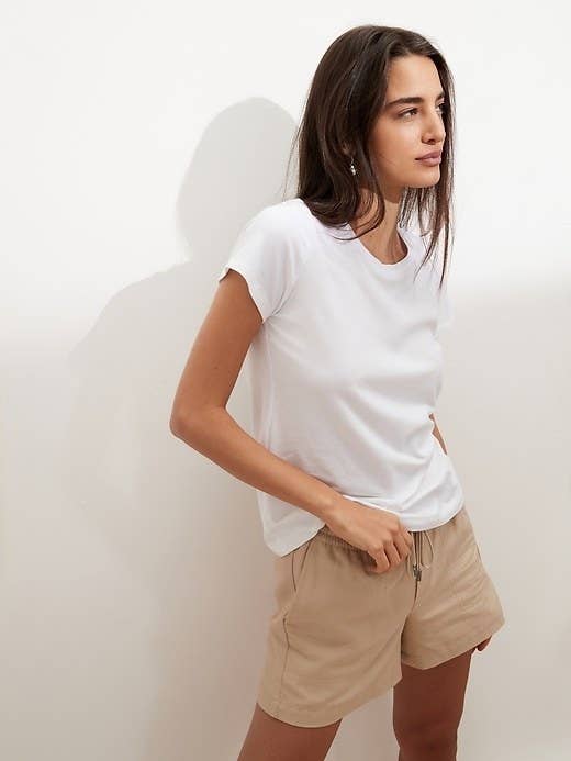 model wearing white crewneck and khaki shorts