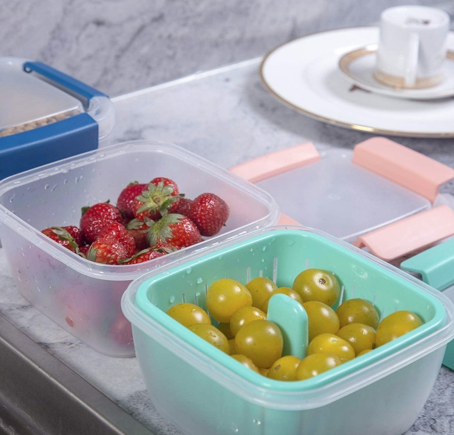 Strawberries and yellow tomatoes in berry box storage container
