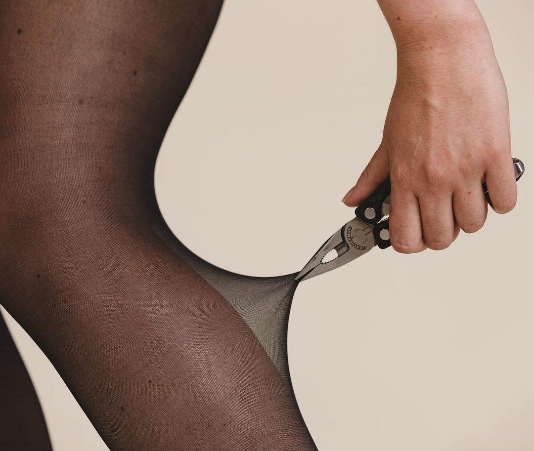 A person pulling at the leggings with pliers