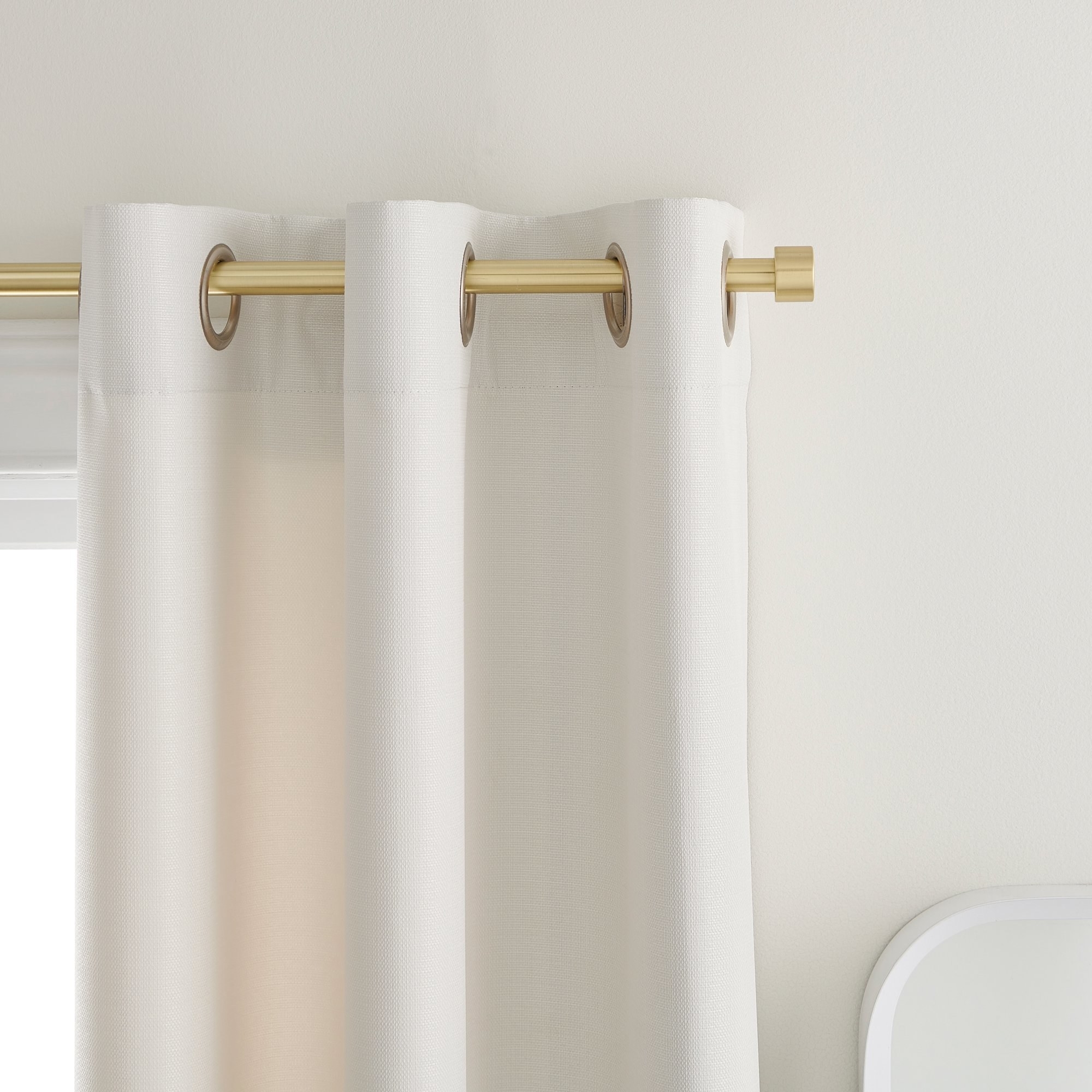 White curtain hanging from gold curtain rod