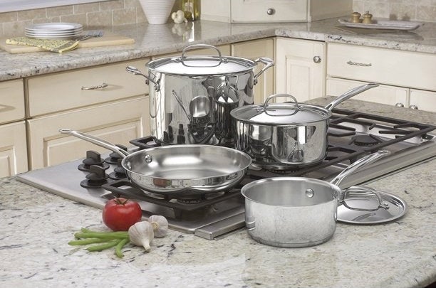 Stainless steel cooking pot set displayed on a stove top.