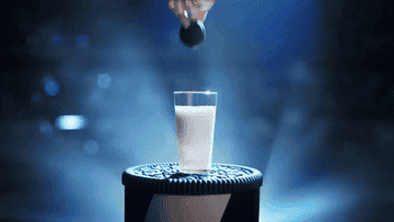 Someone dunking an Oreo into a glass of milk