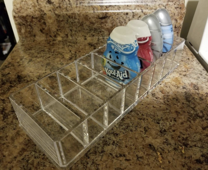 horizontal clear organizer with small squeeze bottles of drink flavoring in them