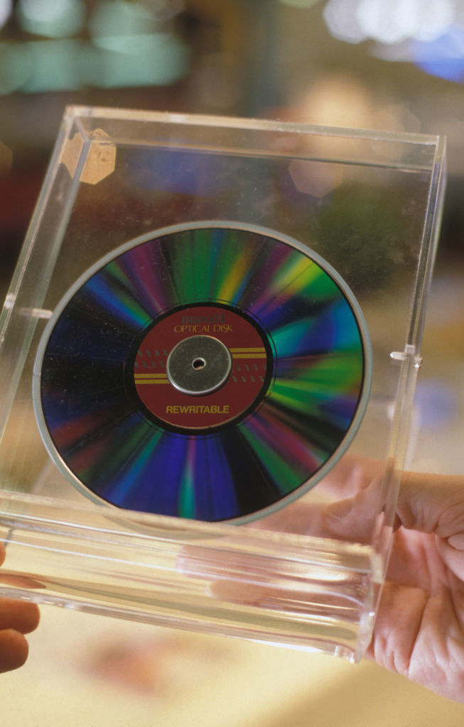 A rewritable CD in a clear plastic case being held in a person&#x27;s hands