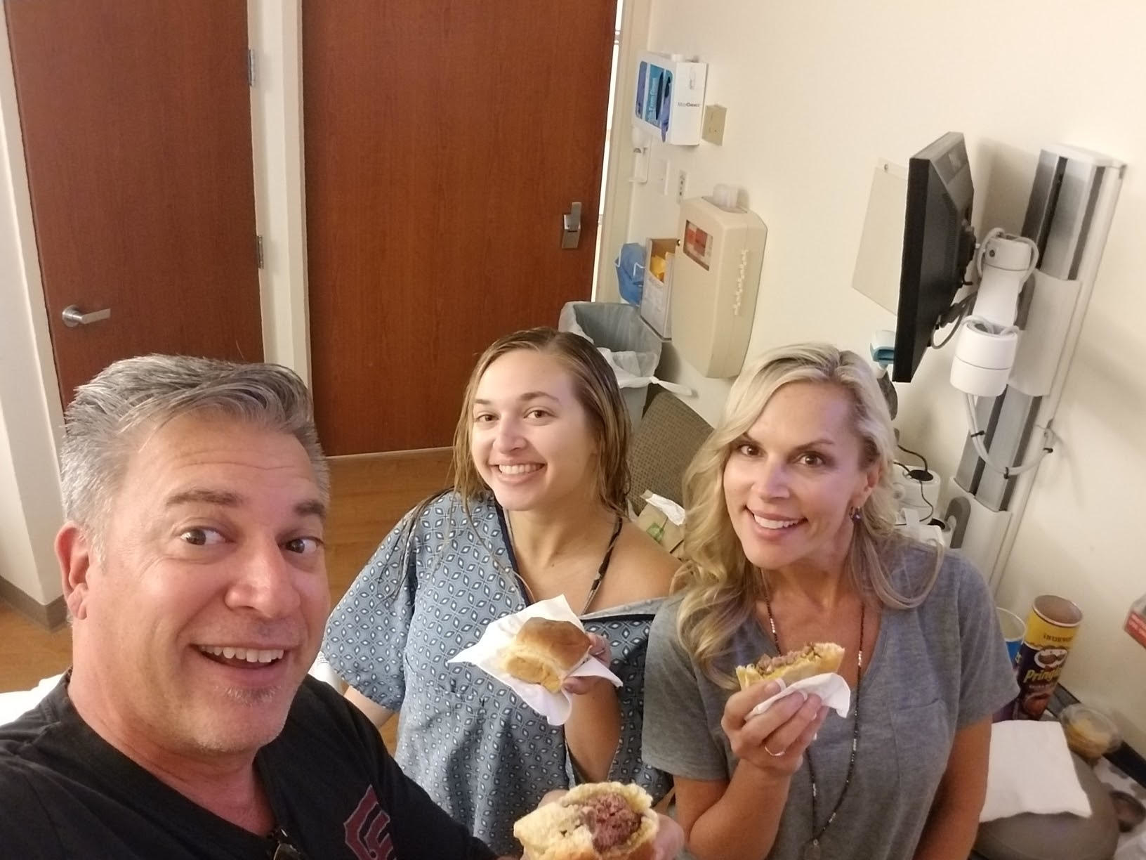 Sam posting with her mom and dad in the ICU