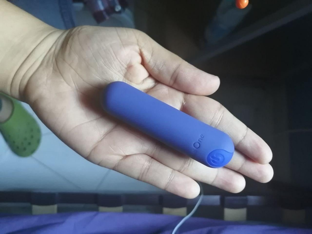 A reviewer holding the small bullet vibrator in the palm of their hand