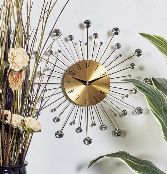 the sunburst clock in gold