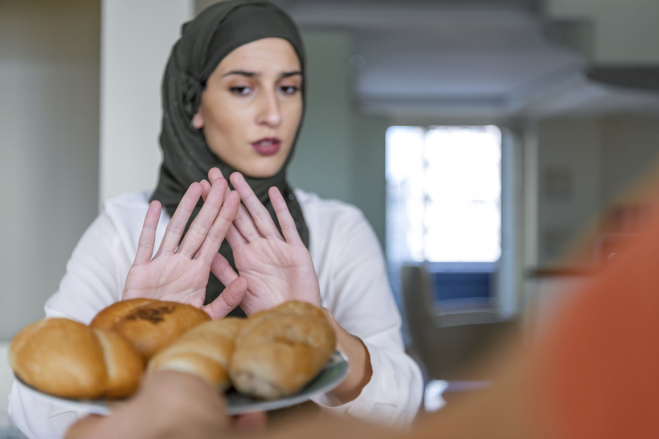 A woman refusing some bread being offered to her