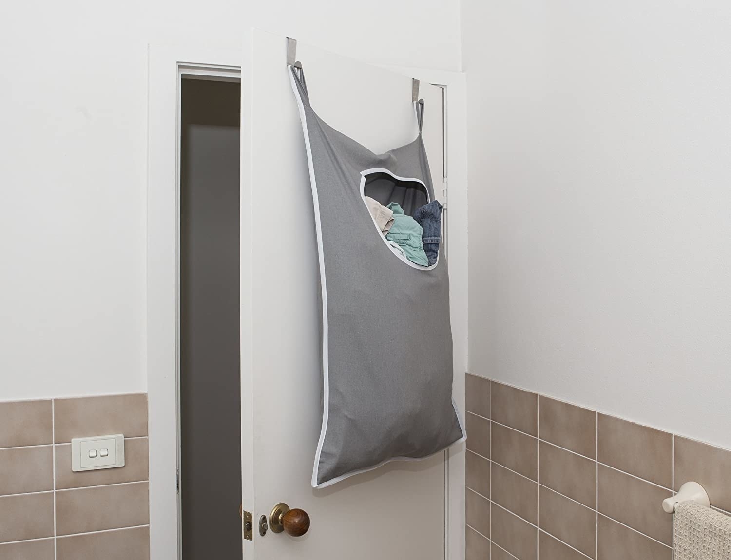 laundry sack with opening in the top hanging on the back of a door