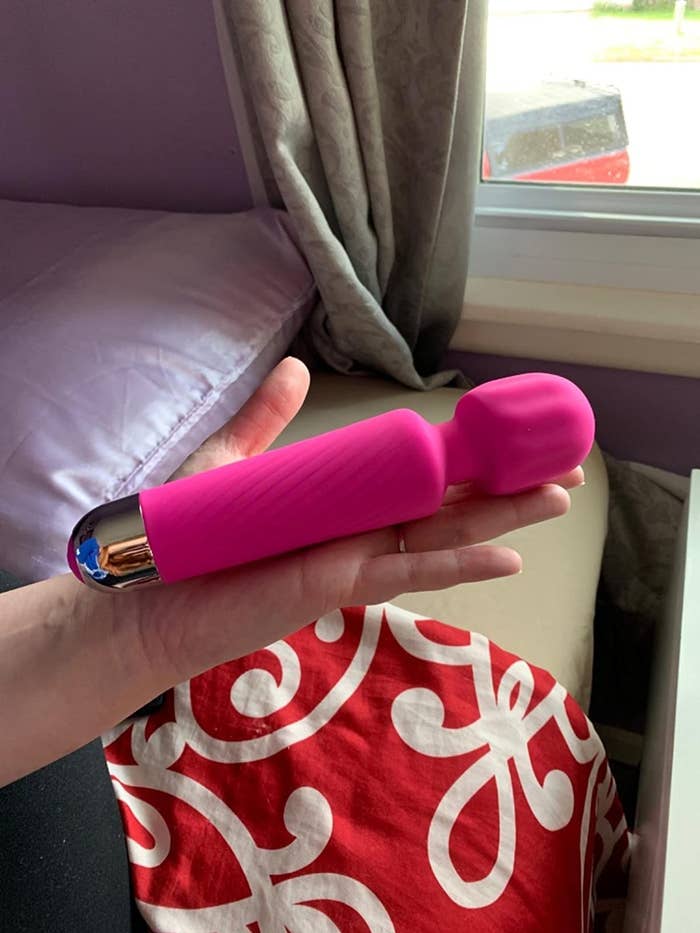 A reviewer holding the vibrator with thick, round head and quilted shaft