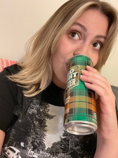 woman sipping a maple pear seltzer from Bud Light