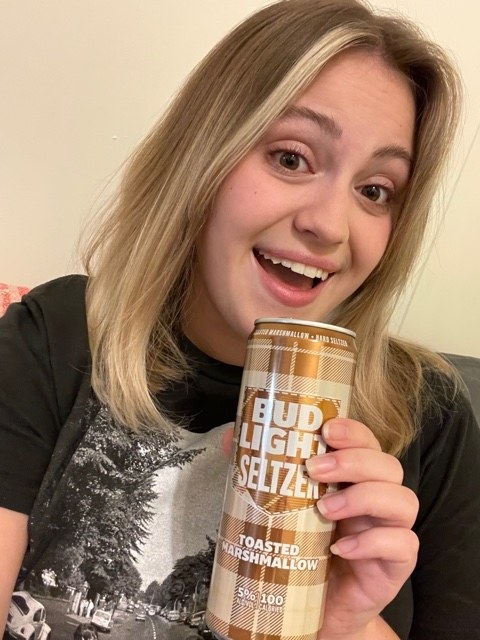 woman holding a toasted marshmallow seltzer from Bud Light and smiling