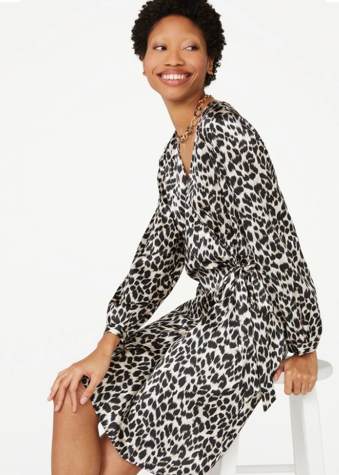 A model wearing a black animal printed wrap dress with long sleeves