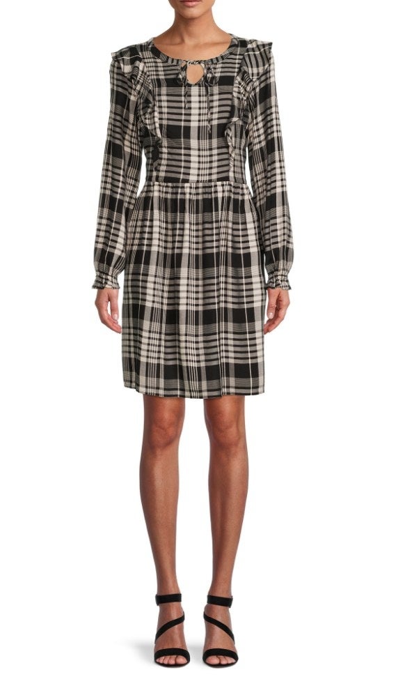 A model wearing a black plaid, knee length dress with ruffles