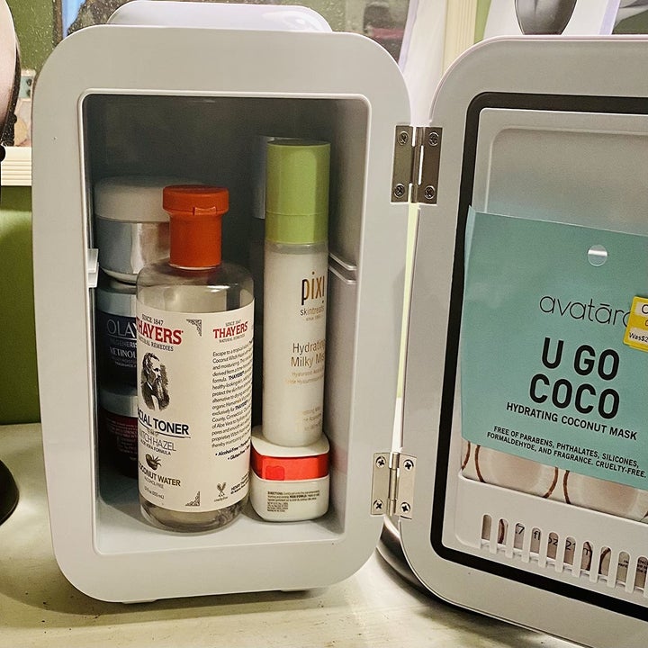 the open mini fridge with skincare items in it