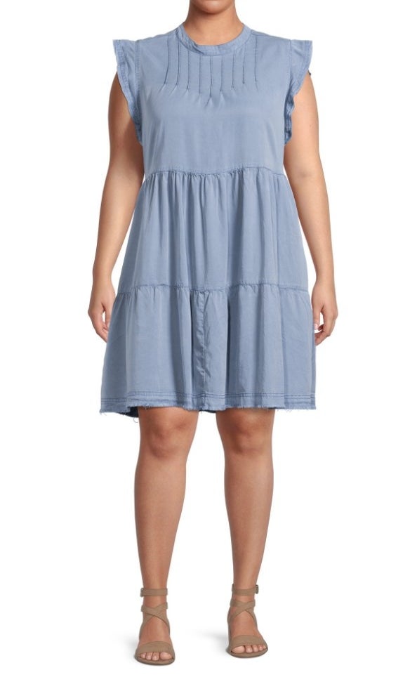 A model wearing a blue linen, sleeveless, tiered dress
