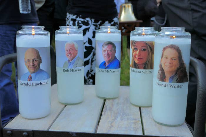 Five faces are printed onto labels of white candles