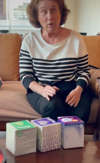 grandma sheila with 3 boxes of tissues on a coffee table in front of her