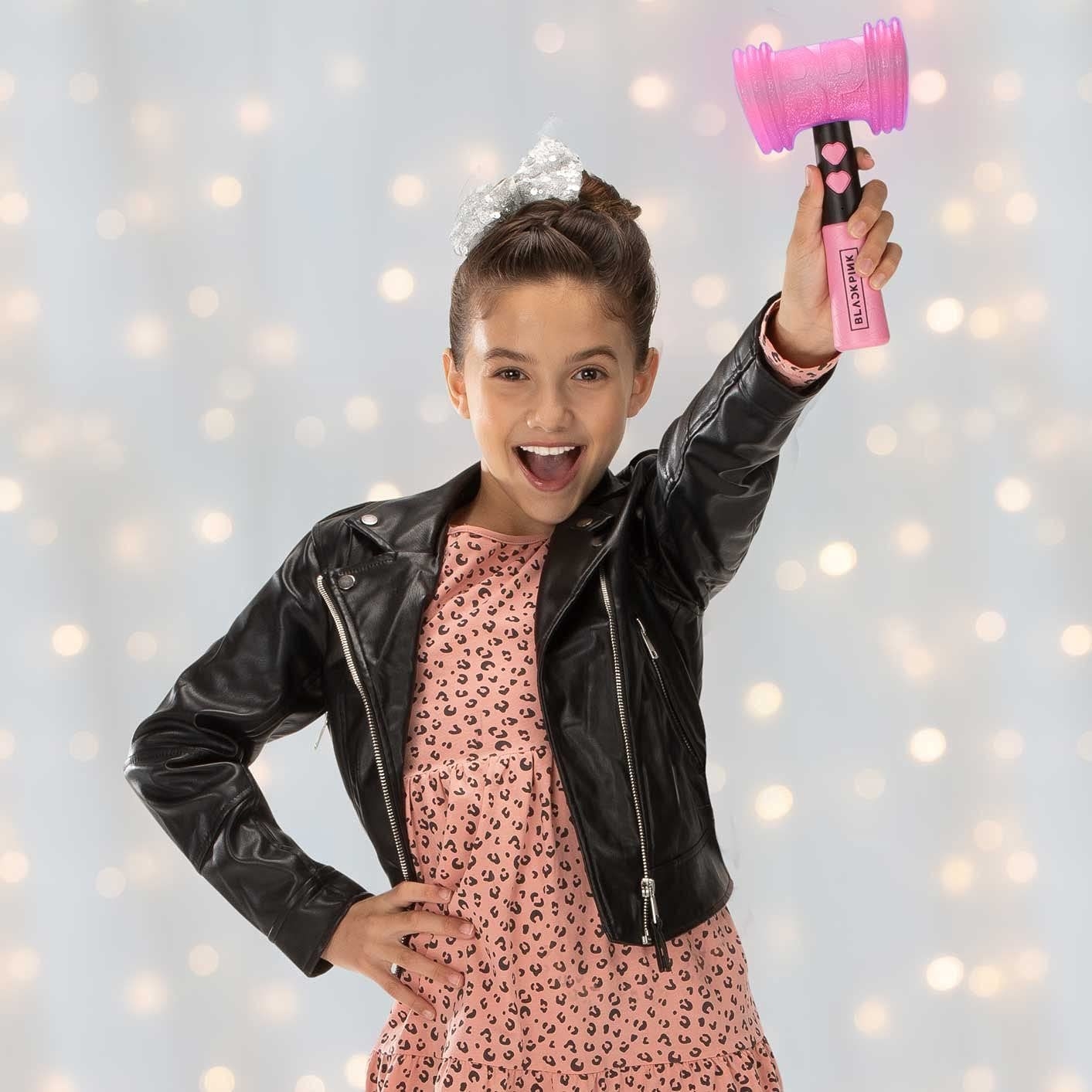 Child model wielding pink and black Blackpink lightstick