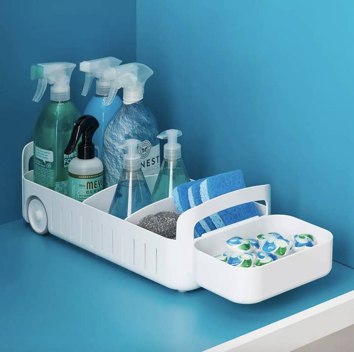 The white pull out organizer under a sink