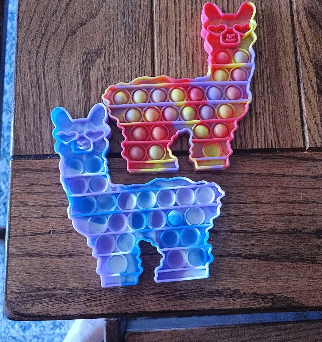 Reviewer&#x27;s image of two colorful llama fidget toys