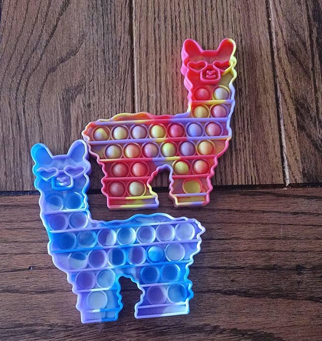 Reviewer's image of two colorful llama fidget toys