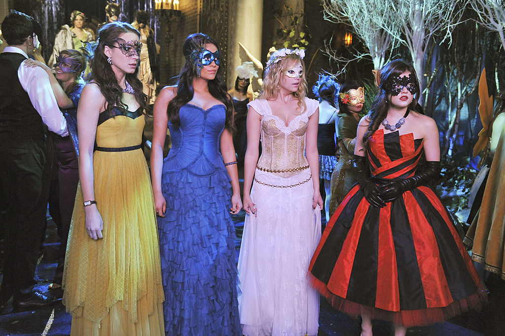 All four girls dressed in dramatic ball gowns for a masquerade