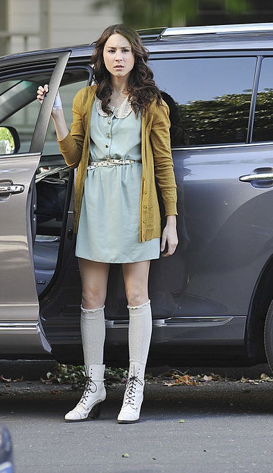 Spencer wearing socks and laced, heeled boots and a dress