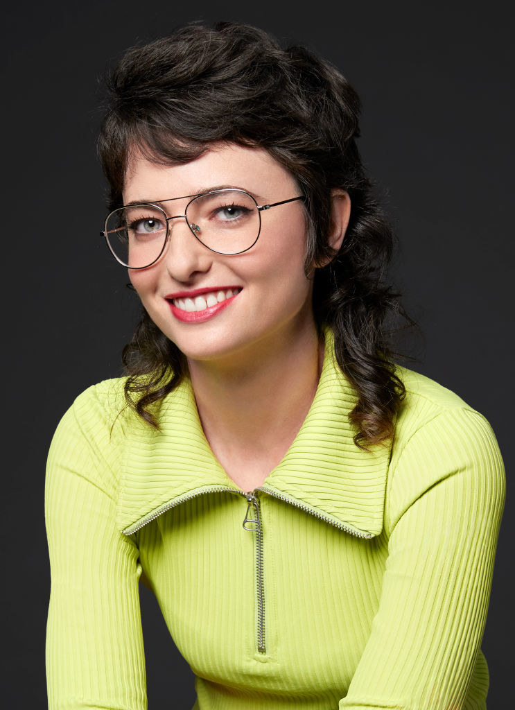 Sarah wearing a neon-colored sweater shirt and eyeglasses