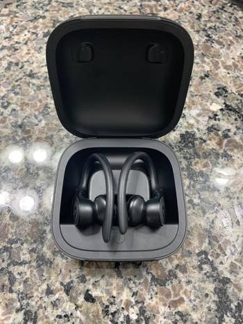 reviewer pic of the same wireless earbuds charging in a black case