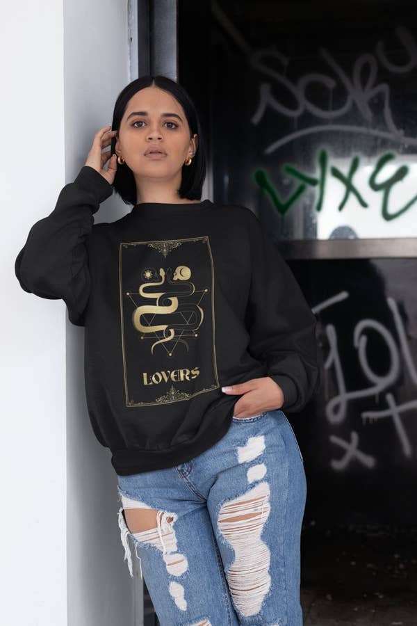 a model wearing the lovers sweatshirt with distressed jeans