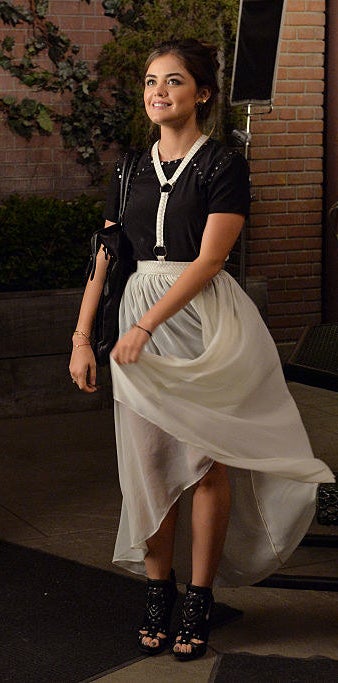 Aria wearing a classic, high-low dress and black heels