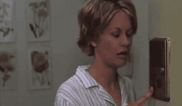 Gif from You&#x27;ve Got Mail of woman answering door for love interest
