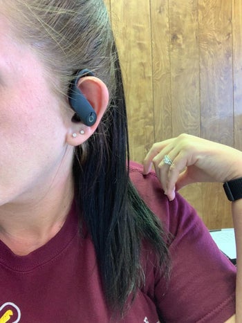 reviewer wears black earbud in one ear