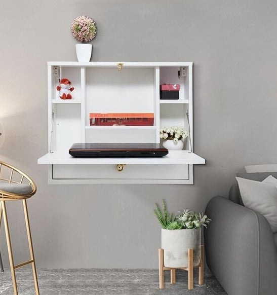 white floating desk with desk compartment that folds down for laptop work and folds up when you're not using it