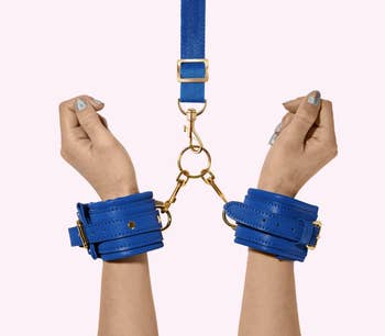 Model wearing blue faux leather handcuffs