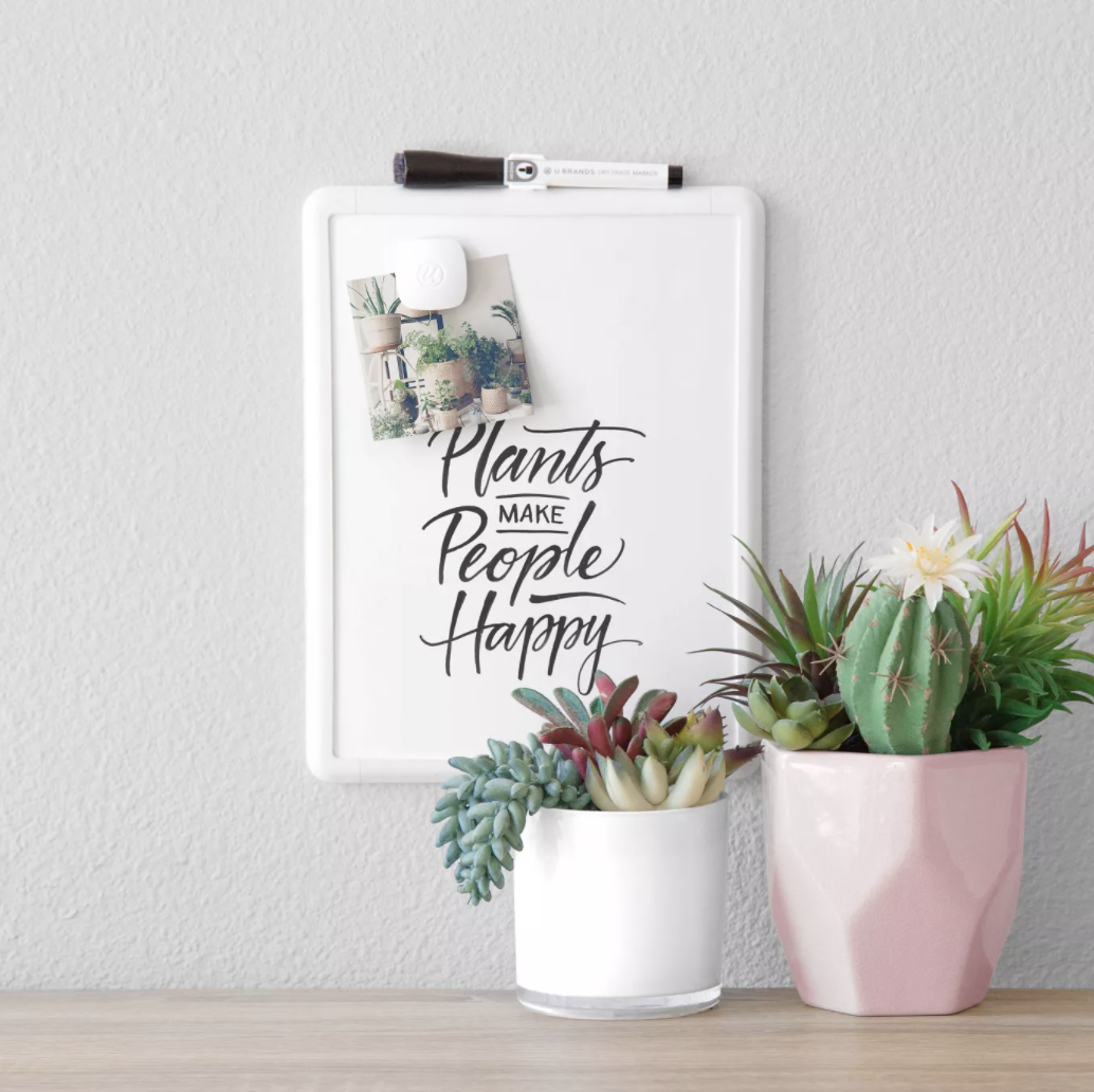 white dry erase board that says "plants make people happy" in black marker