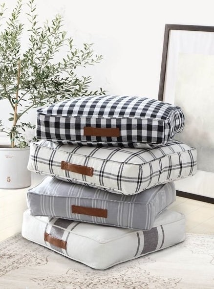 Stack of four floor pillows in different patterns.