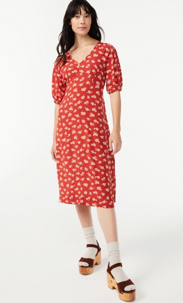 A model wearing a v-neck midi dress in red/cream flower print