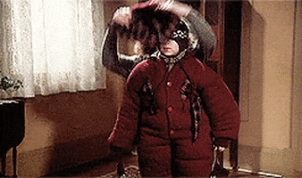 a gif from a christmas story where the mom is laying clothes on her son