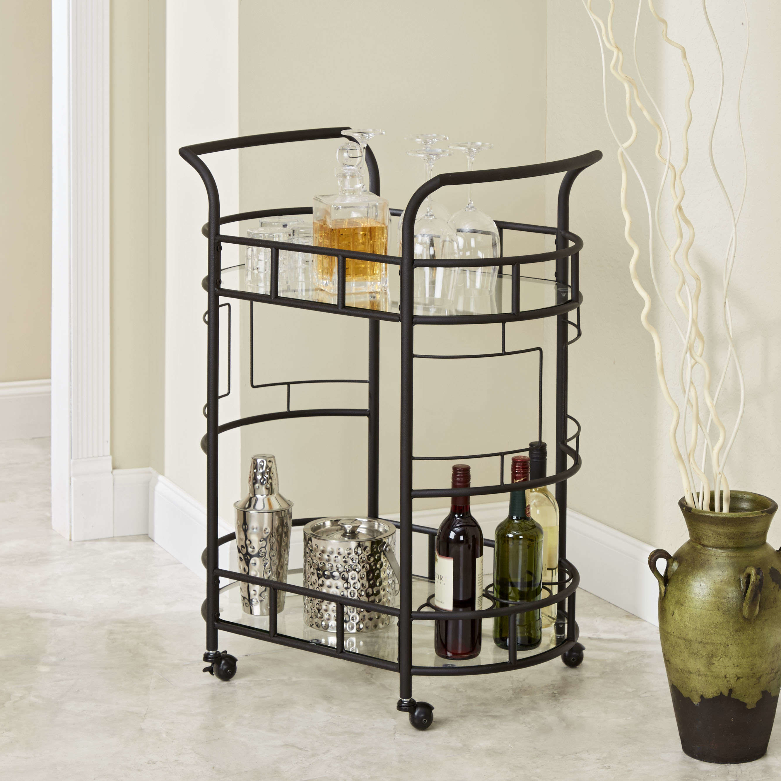 Bar cart filled with bottles, accessories and glasses.