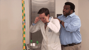 Gif of Daryl helping Andy use an eye wash in The Office