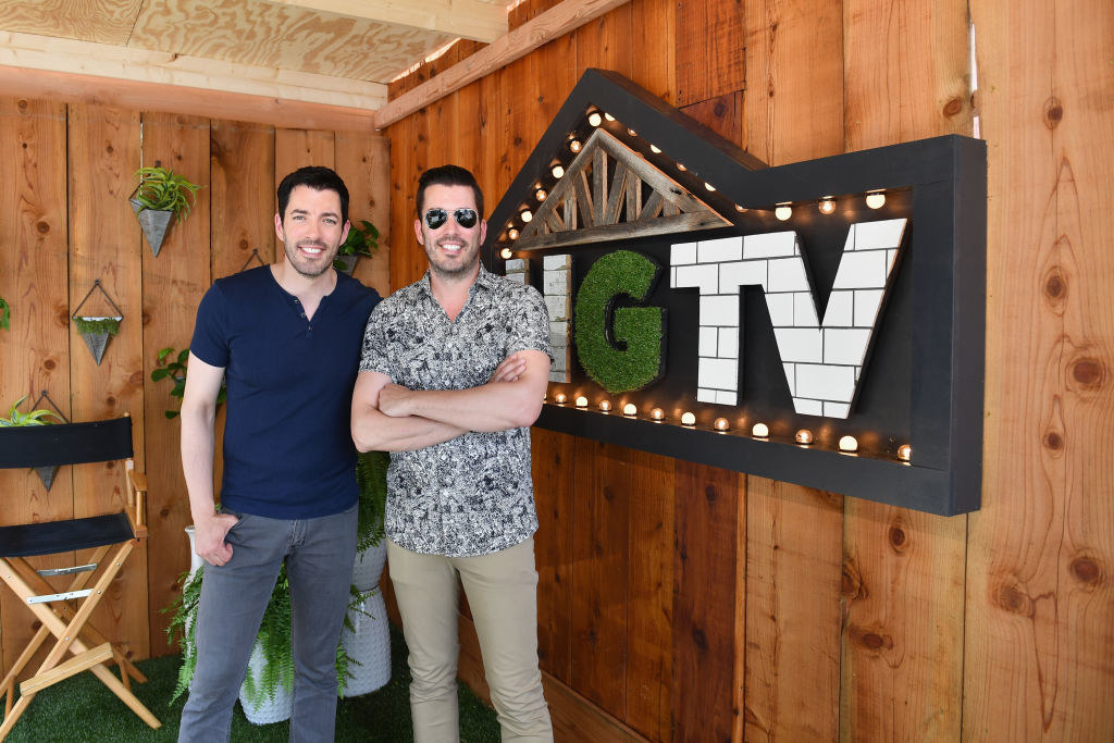 The Property Brothers pose next to HGTV sign