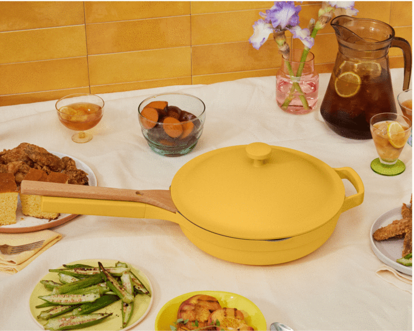 the Our Place pan in yellow styled on a table with cooked foods