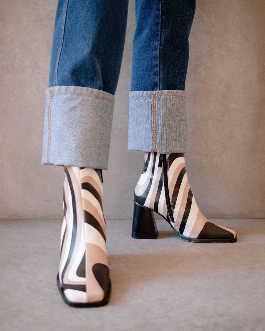 Model wearing the boots with black, tan, and white swirl attern