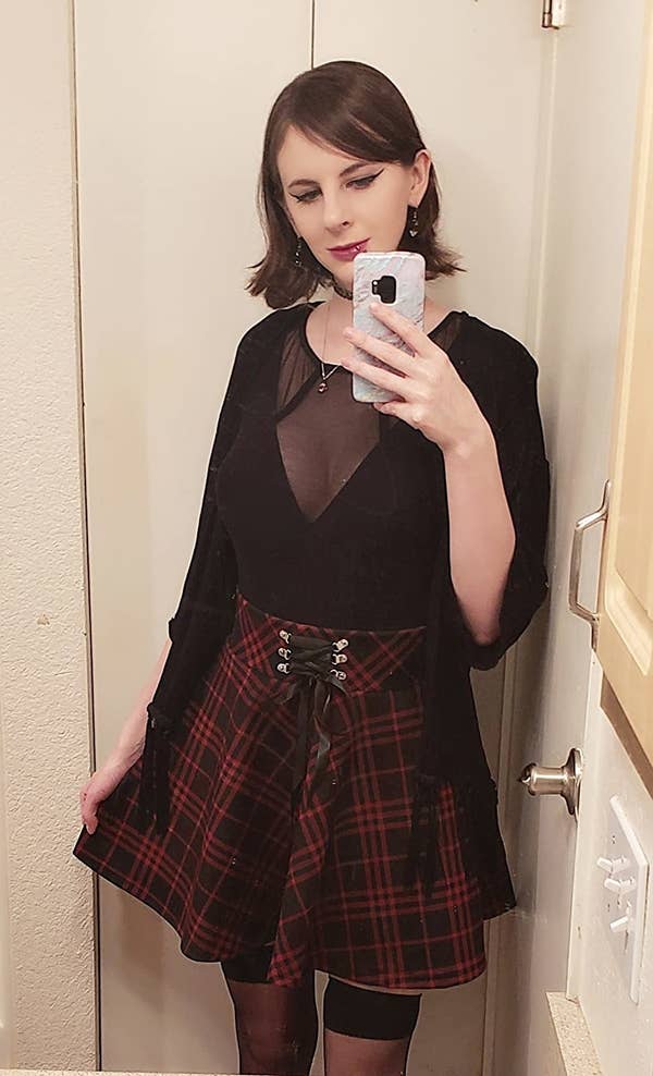 reviewer mirror selfie wearing the red and black gothic skirt with a black mesh top