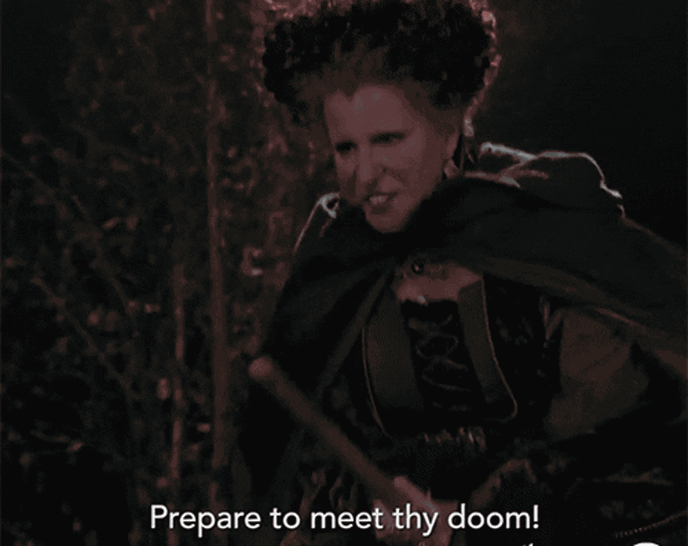 a gif of bette midler in hocus pocus flying on a broom and saying prepare to meet thy doom