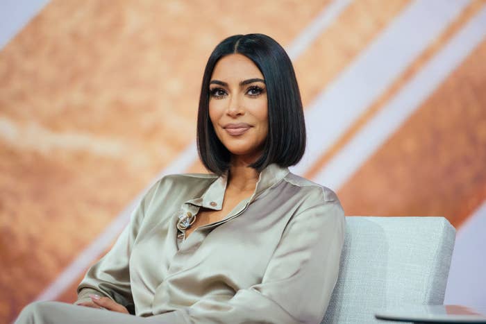 Kim sitting for an interview in a satin outfit and a bob haircut
